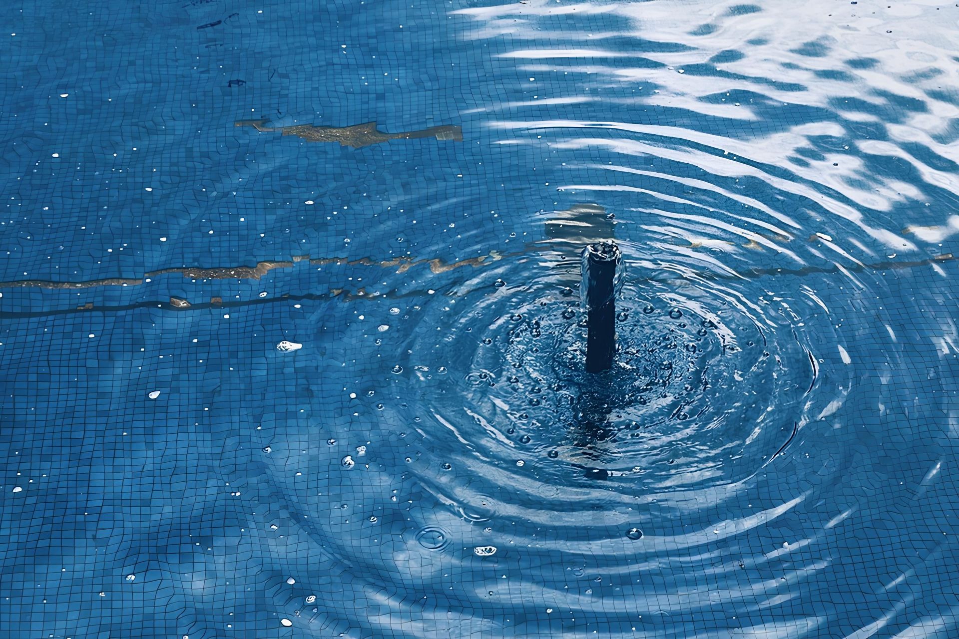 Close-up of rippling effect in a blue tiled pool with water movement.